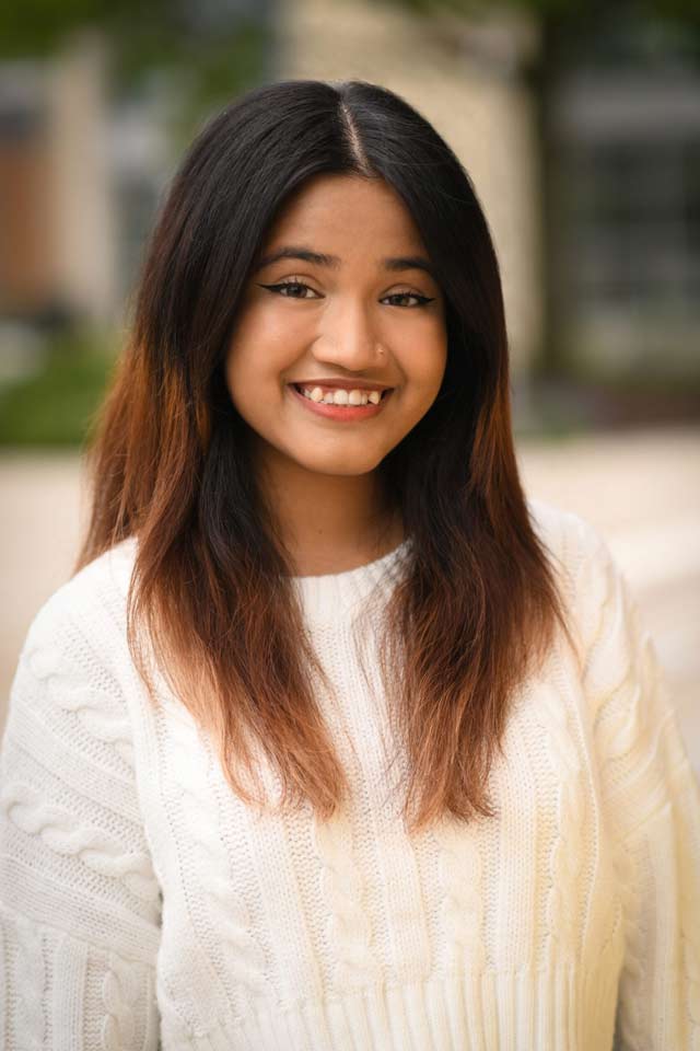 A young female research student smiling towards the camera