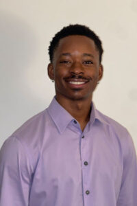 a three-quarter portrait of a young undergraduate student smiling.