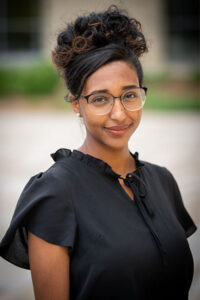 a three-quarter portrait of a young undergraduate student smiling.