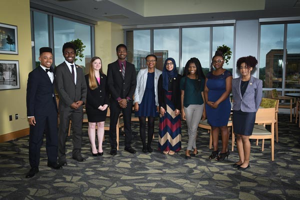 A group of undergraduate students in line, posing as they are being accepted into the new cohort